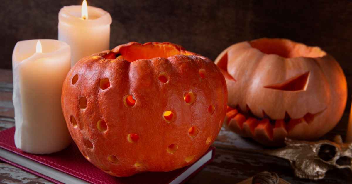 water inappropriate pumpkin carving ideas with glowing jack o lantern and candles on wooden tablelit