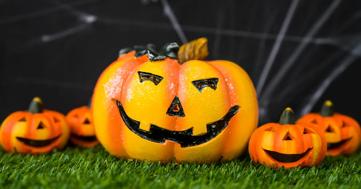 Sports Pumpkin Carving Ideas jack o lanterns on grass with glowing faces and Halloween decor backdrop