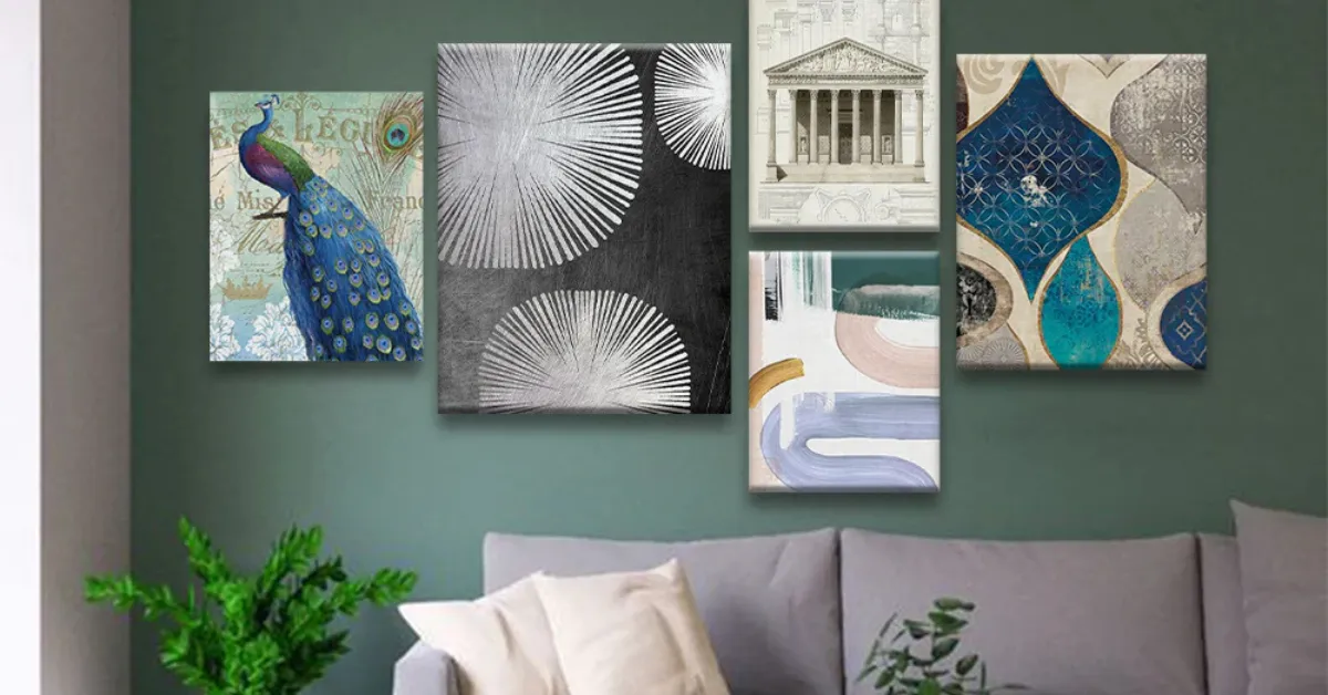 Modern living room wall with a green backdrop featuring a gallery of five canvas paintings, including a peacock artwork, abstract patterns, geometric designs, and architectural art above a neutral sofa with decorative cushions and a plant nearby.